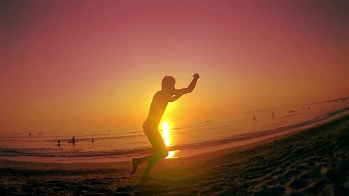 跑酷自由跑步者在夏日海滩日落时奔跑和跳跃后空翻。Steadicam慢动作镜头