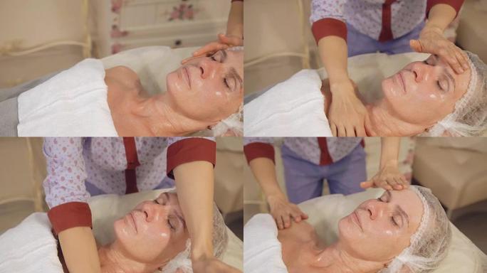 中年妇女在水疗沙龙中进行面部和颈部淋巴，引流按摩