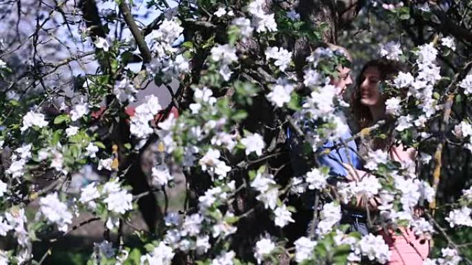 感性的夫妇在开满小白花的樱桃园里找到了隐私。英俊的小伙子和漂亮的姑娘甜言蜜语
