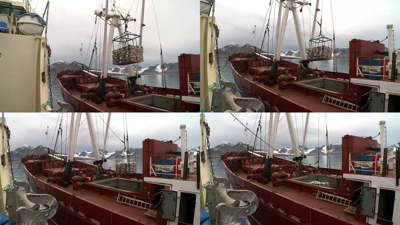从运输船上的拖网渔船上卸下鱼