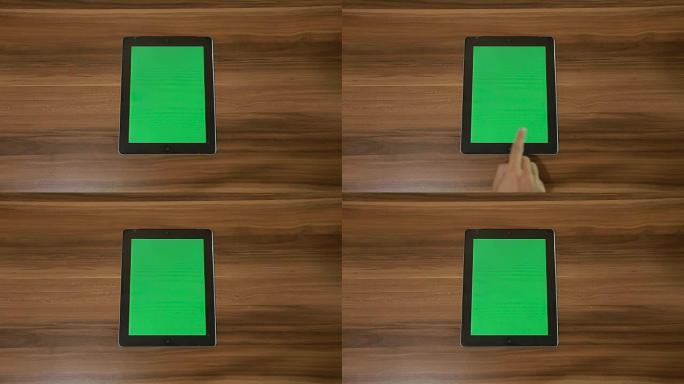 男子手使用垂直数字平板电脑，在木桌背景上向左滑动绿色
