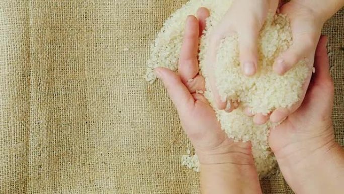 两对手-一个成年妇女和孩子拿着一粒米