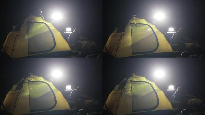 两名男子在远征SUV上搭建帐篷的夜间拍摄。