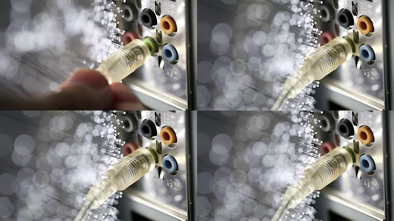 音频线连接到具有光纤背景的计算机，高清拍摄