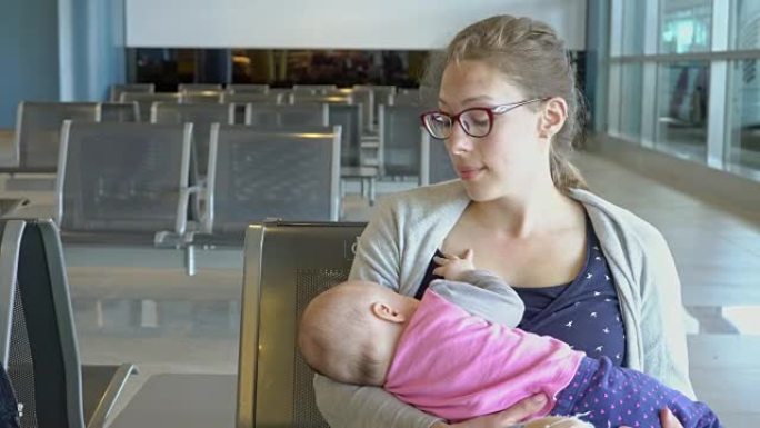一名妇女在机场给孩子喂奶