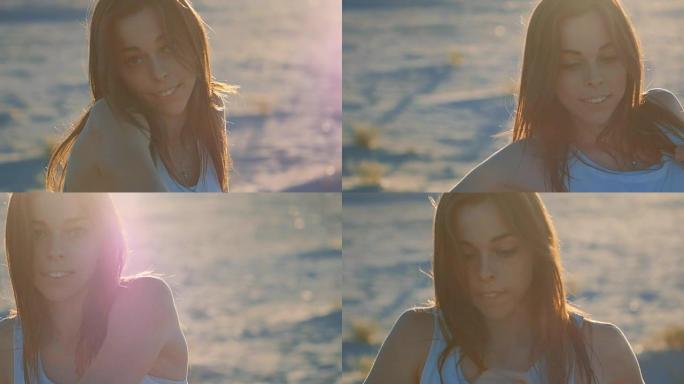 美丽的女孩在日落时以慢动作在海上背景下摆姿势