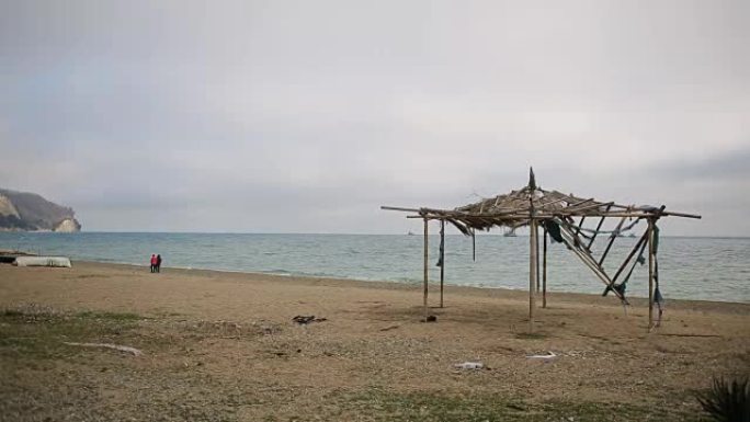 废弃海滩上倒塌的竹子遮阳篷。不是季节，生态概念