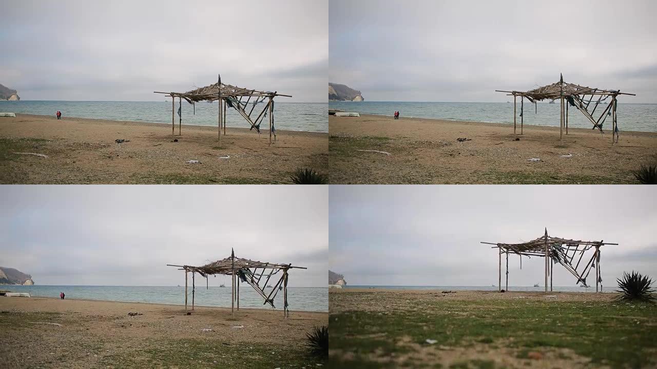 废弃海滩上倒塌的竹子遮阳篷。不是季节，生态概念