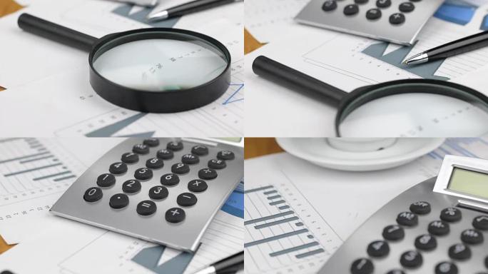 放大镜、钢笔和计算器放在图形和图表上，特写。多莉。