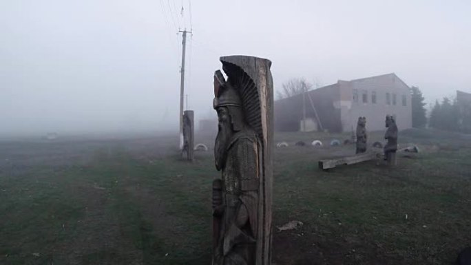 在乌克兰内陆被遗弃的木制雕像，早春被践踏的乡村荒野的雾蒙蒙的风景