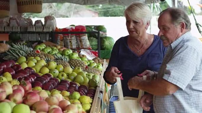 老年夫妇从市场上购买水果
