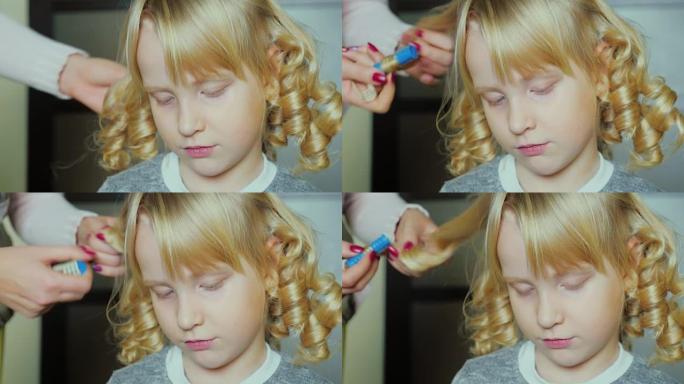 金发有趣的女孩5年用卷发器缠绕头发