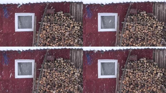 靠近谷仓墙的柴火堆和冬季降雪