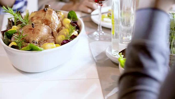 餐桌上有鸡肉和土豆食物细节。四个快乐的真正坦率的朋友喜欢在家里或餐馆一起吃午餐或晚餐。4k视频