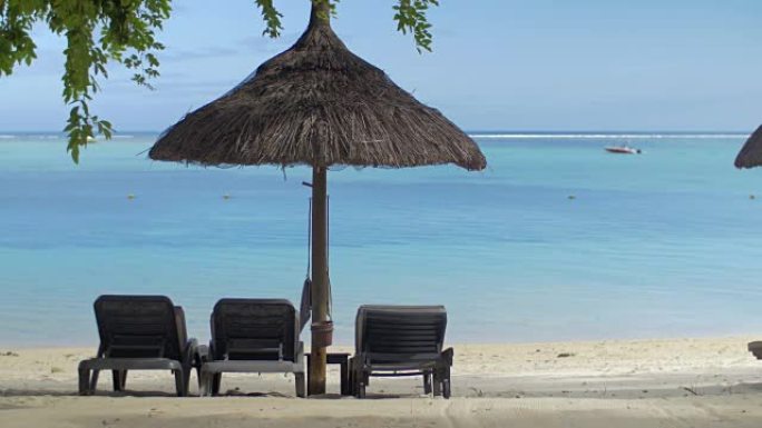 毛里求斯岛蓝水原生太阳伞附近空躺椅的景色