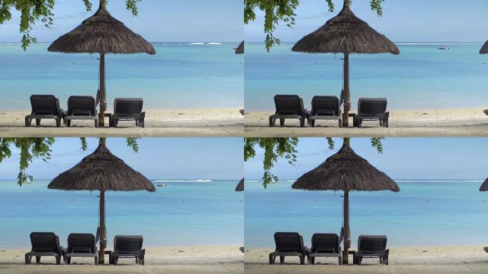毛里求斯岛蓝水原生太阳伞附近空躺椅的景色