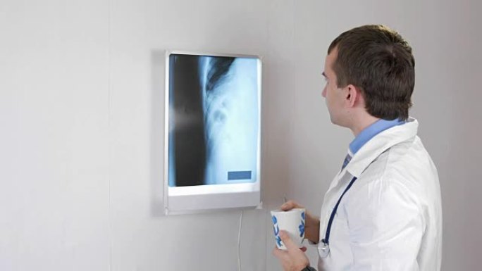 医生检查x光，喝一杯热饮。白色墙壁和带有肋骨和胸部的黑管镜