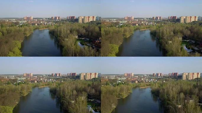 德斯纳河、树木和特罗伊茨克市的鸟瞰图。新莫斯科。摄像机在河上水平缓慢向前移动。春天的时候。晴朗的天气