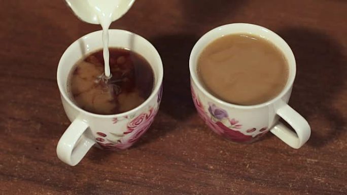 牛奶倒入两个咖啡杯的特写镜头。