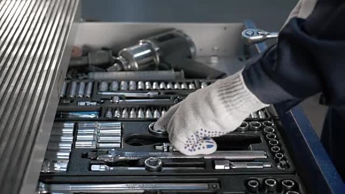 现代服务站汽车维修用不同工具的机械师打开蓝色金属盒