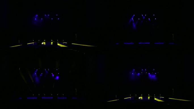 舞台上黑暗中的蓝色和黄色聚光灯。