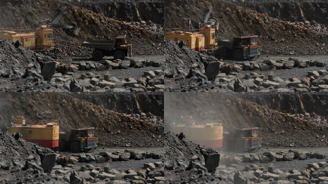 挖掘机在采石场开采花岗岩的重型卡车上装载一块石头