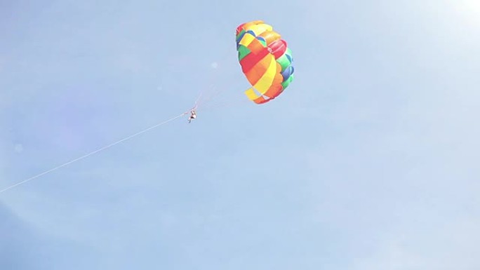 一艘被船拖拉在天空中飞行的多色降落伞