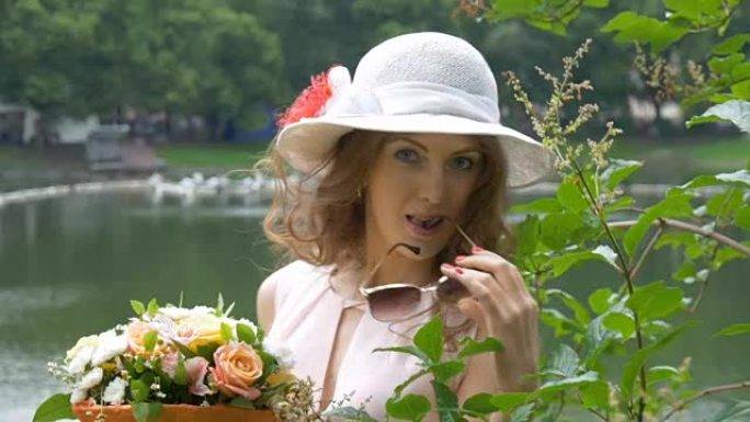 一个戴着白帽子的美丽白人女孩，带着一束鲜花。