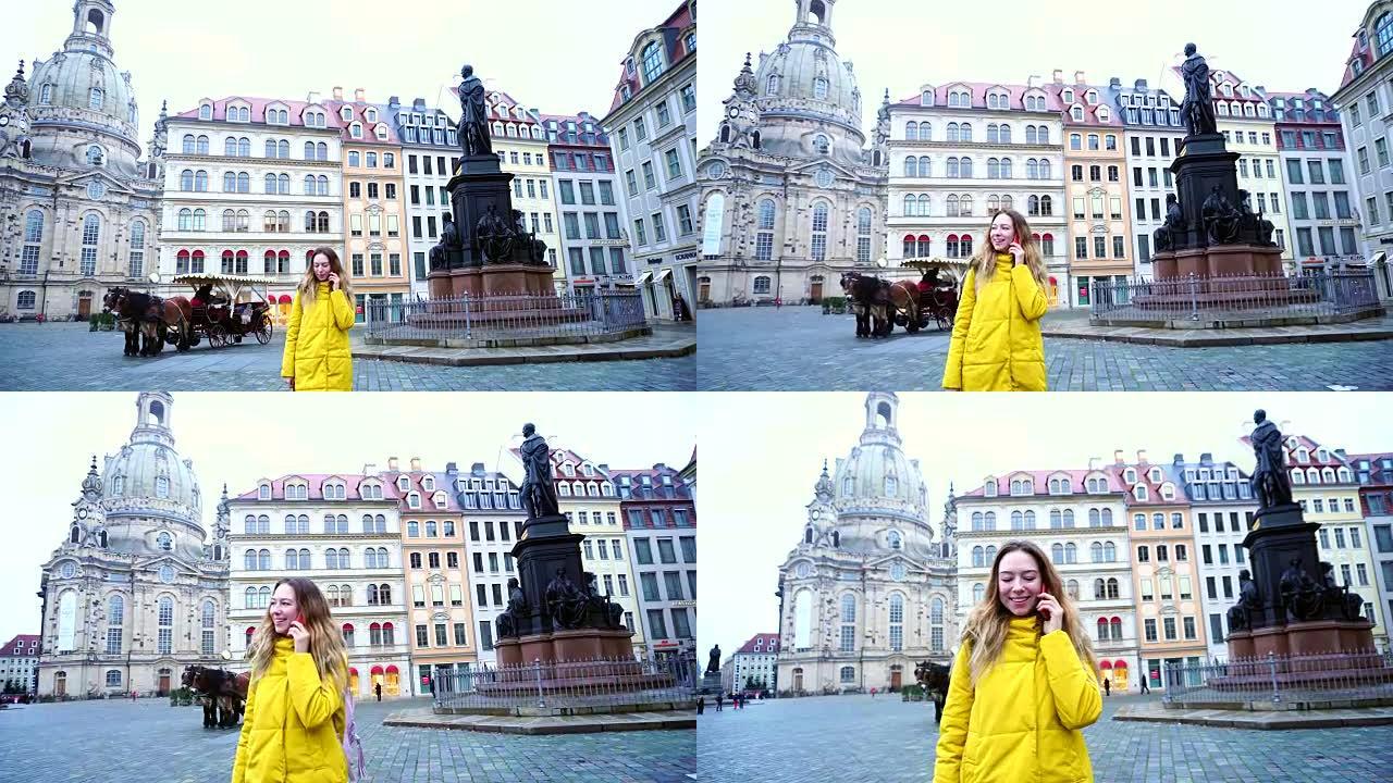 诱人的女孩在电话里聊天，在欧洲城市德累斯顿散步，冬天下午户外美丽的房子和纪念碑的背景下