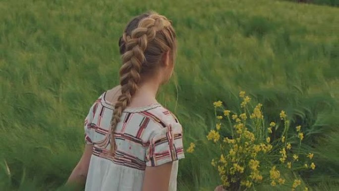 可爱的年轻女孩在田野里散步，拿着一束油菜花