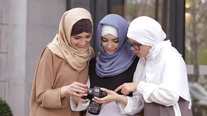 年轻的穆斯林女孩看照片