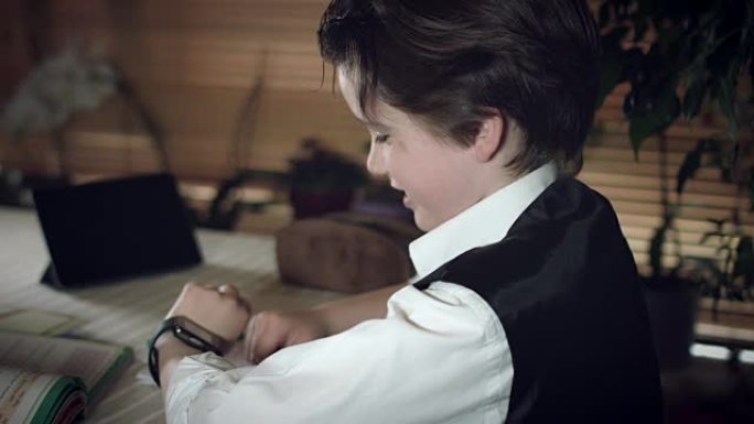 4k高科技拍摄的孩子在智能手表上做作业并与妈妈交谈的照片