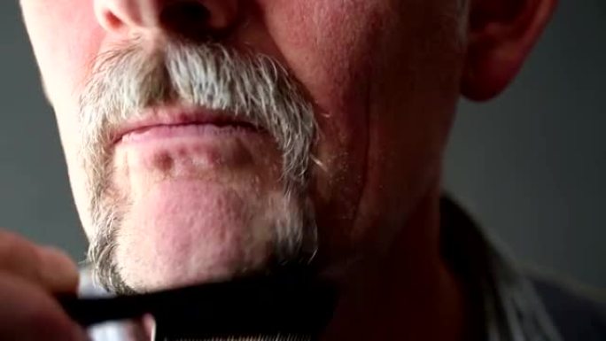 50多岁的男人梳理胡须的特写镜头