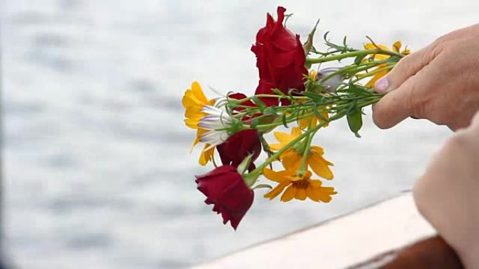 以水为背景，手捧一束玫瑰。为了纪念卫国战争和斯大林格勒战役中阵亡的将士。登上伏尔加格勒河上的船