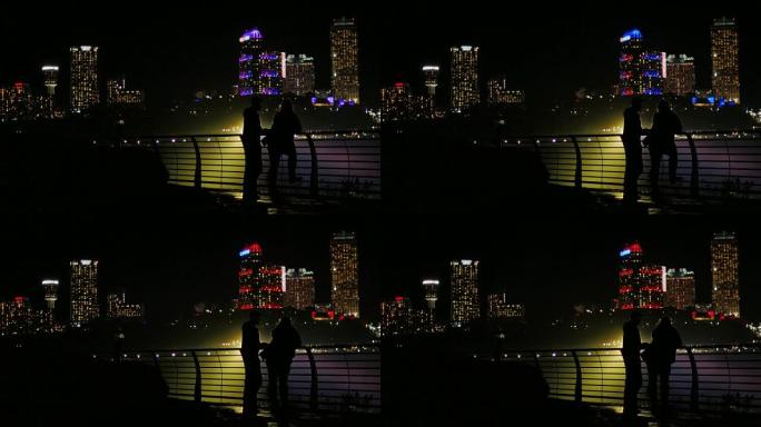 夜城摩天大楼背景下的男女剪影。通信，全长，标题的自由空间