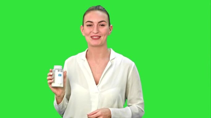漂亮的女人在绿色屏幕上描述和广告镜头的药丸，色度键
