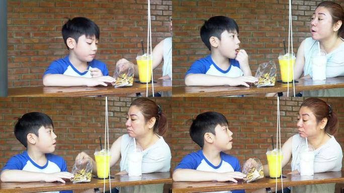快乐的亚洲妈妈和她的儿子一起吃零食和玩耍