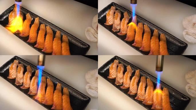厨师使用燃烧的火炬燃烧鲑鱼寿司
