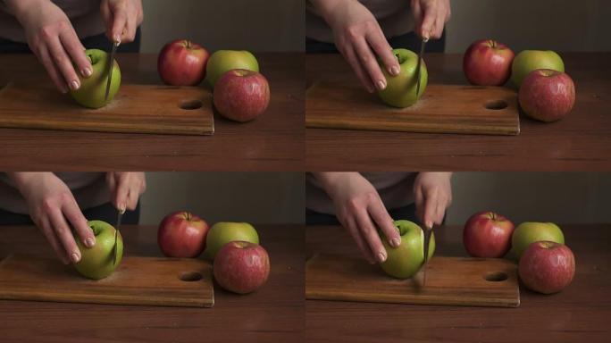 女人的手在木板上切苹果。