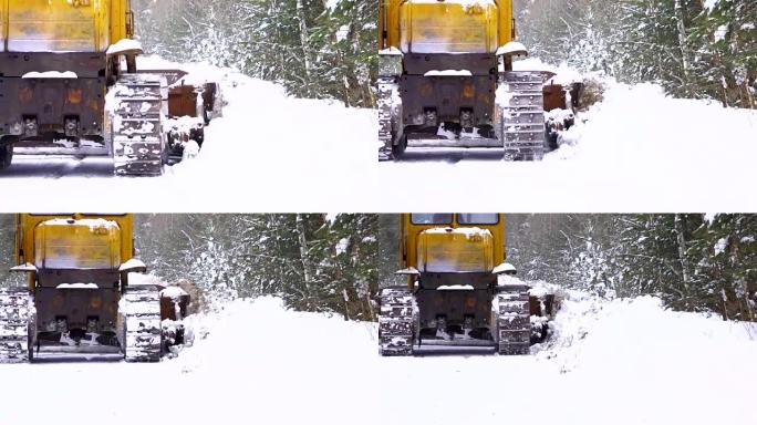 清除道路上的积雪。履带式拖拉机平地机清除道路上的积雪。