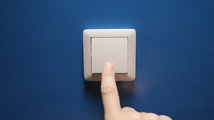 人手关闭蓝色墙壁上的电源按钮