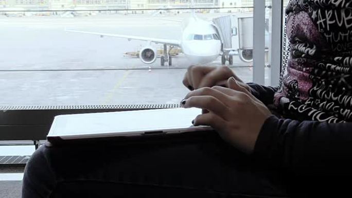 在机场使用平板电脑的女人的手