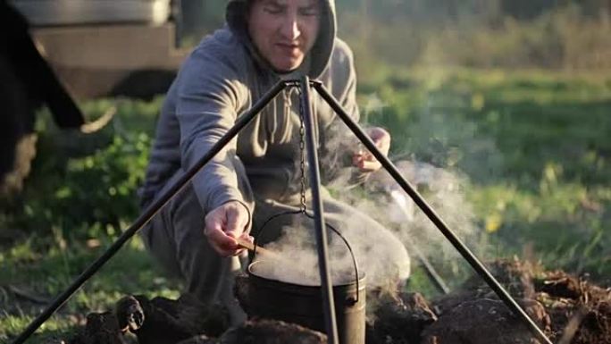 白种人在露营的篝火上在boowler做饭。