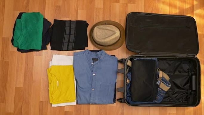 游客的俯视图旅游概念有序地将衣服装进手提箱