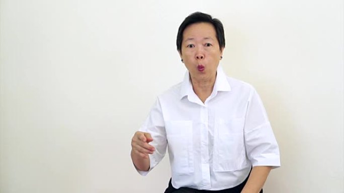 亚洲女性老人看着相机摇头，做手势拒绝，说不