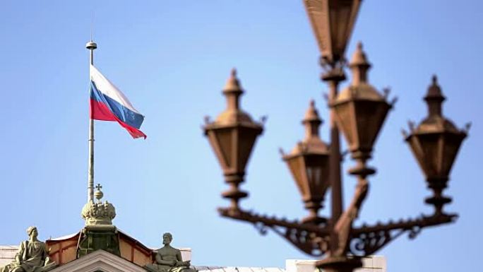 蓝天背景下的旗杆上飘扬着俄罗斯国旗