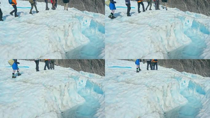 指南打破冰川，与指南一起使用冰镐穿过冰川隧道。新西兰福克斯冰川