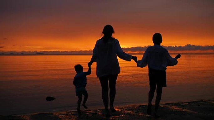 日落时分，一家人牵着手在海滩上奔向大海