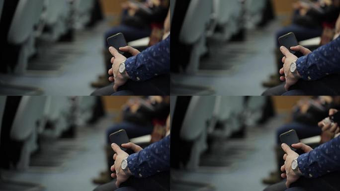 女人抱着手机在膝盖旁，手握手表，坐在大厅里