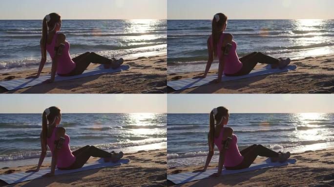 健身女子在海滩上听音乐时锻炼后放松
